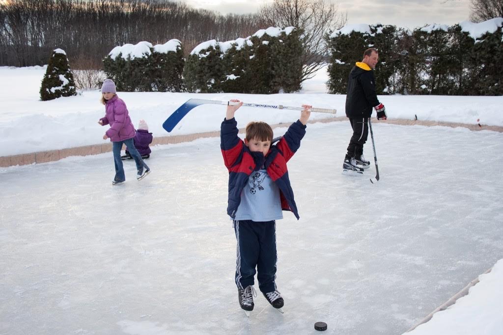 Children enjoying ice skating on an outdoor rink in winter.